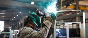 A welder works on a structure in the weld shop.